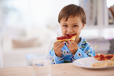 Buy stock photo A cute little boy eating toast with jam