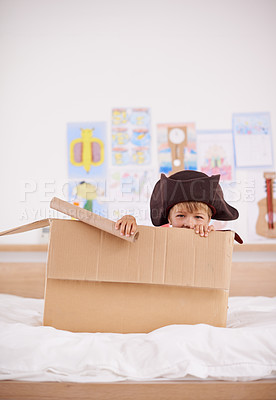 Buy stock photo Home, portrait or costume as pirate to play in boat boxes or fantasy in bedroom or house. Kid hiding, child captain or boy in an adventure game with cardboard or monocular telescope to sail on ship