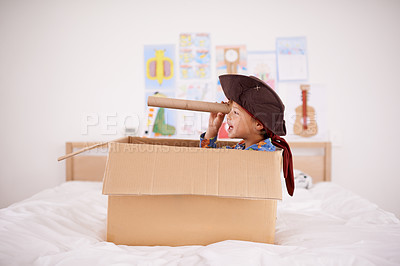 Buy stock photo A little pirate spying land from his cardboard box boat