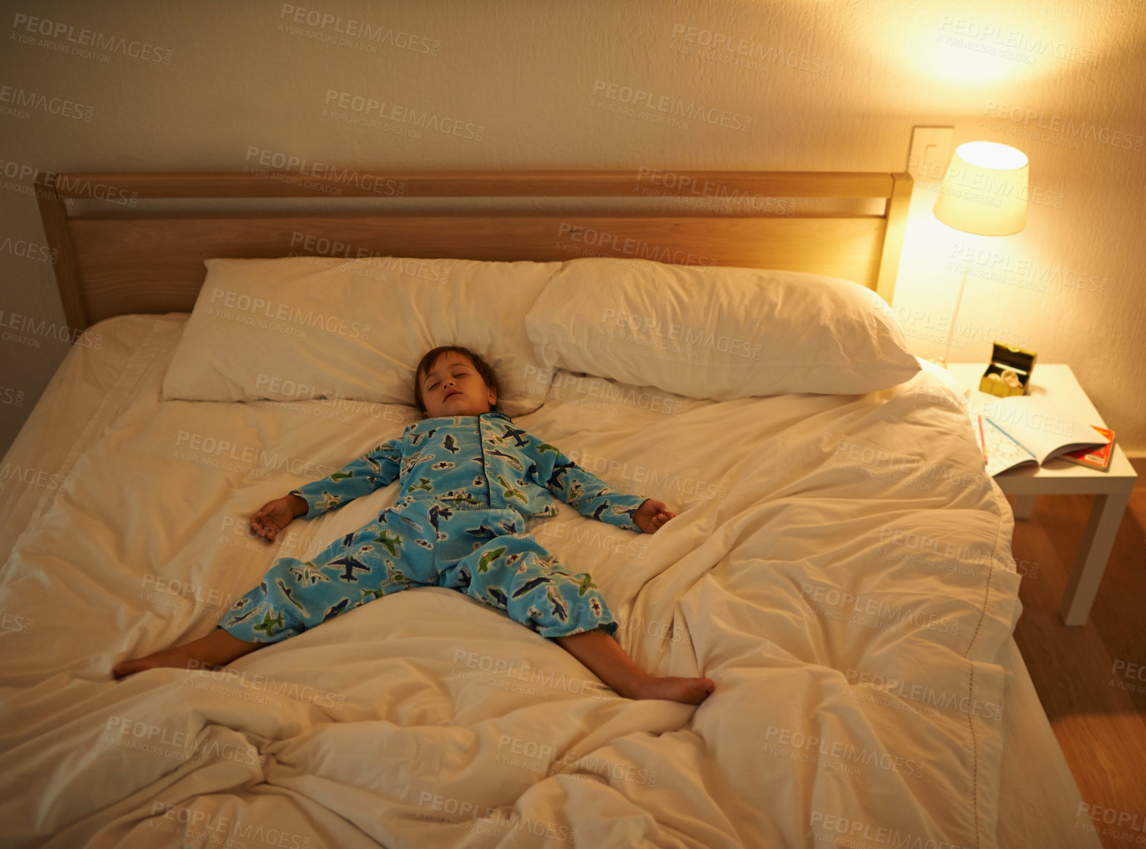 Buy stock photo Boy, bed and rest for night, sleeping and tired with fatigue and peace. Child, dreaming and exhausted with pyjamas, dark and bedroom with lamp for serene childhood at home or house for calm kid