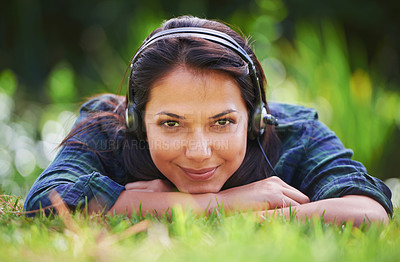 Buy stock photo Grass, portrait and woman with headphones, park and streaming audio with peace, sound and sunshine. Person, outdoor and girl with headset, summer or podcast with radio, relaxing or listening to music