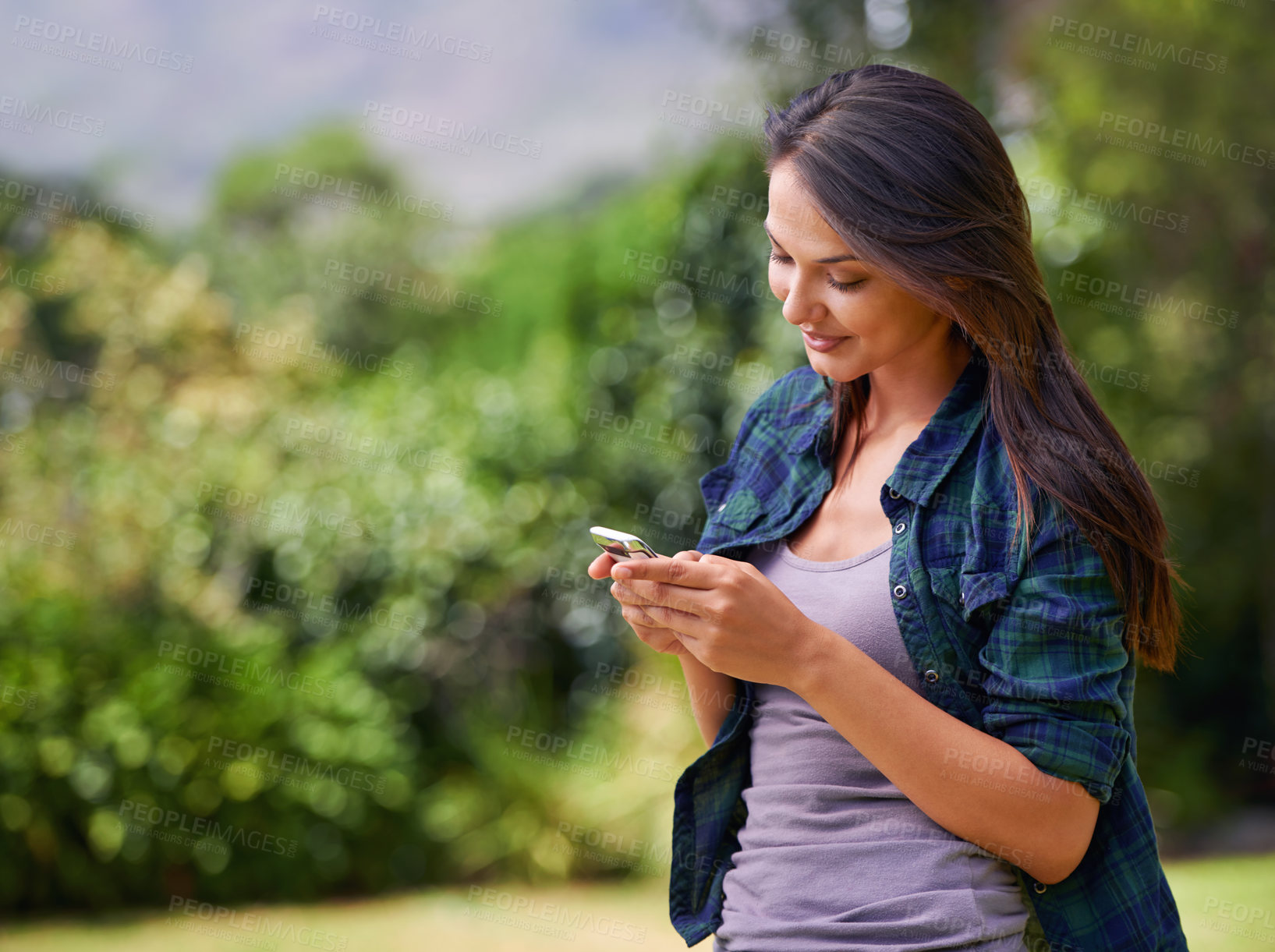 Buy stock photo Smile, cellphone and woman in nature networking on social media, mobile app or internet for communication. Happy, technology and young female person scroll on a phone in outdoor garden, field or park