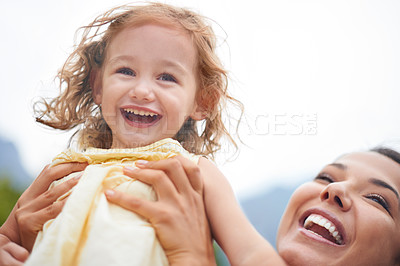 Buy stock photo Cropped shot of a joyful mother lifting her daughter to the sky