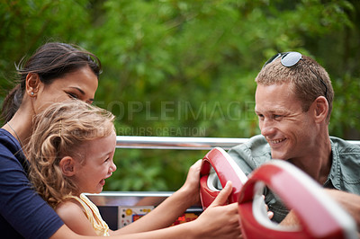 Buy stock photo Shot of a happy young family sitting on a bus
