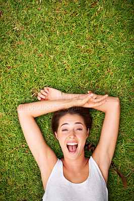 Buy stock photo Aerial shot of a young woman lying outside on the grass