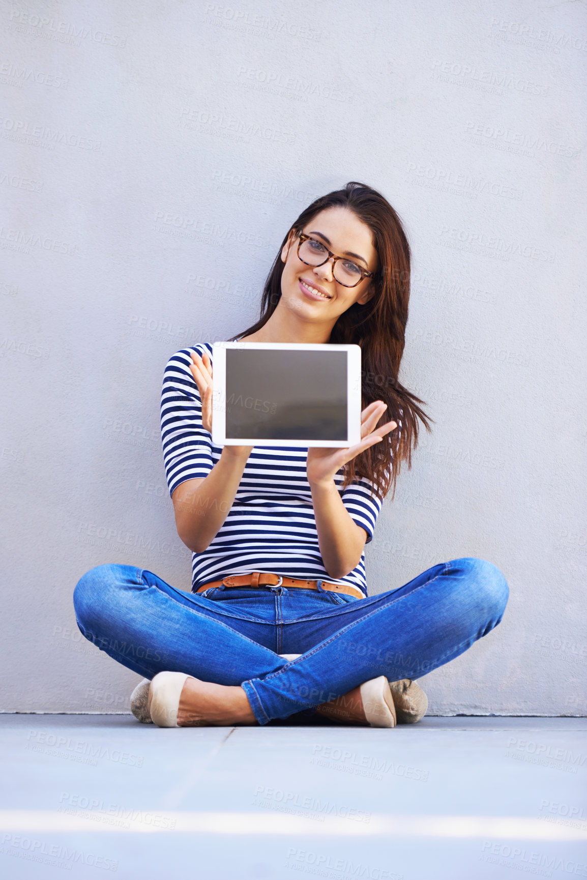 Buy stock photo Full-length shot of an attractive young woman holding up a digital tablet with a blank screen