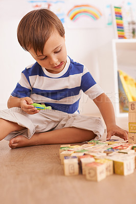 Buy stock photo Boy, child and building blocks for toys, playing and learning with development and growth at home in playroom. Fun, activity and playful with wood bricks, young toddler kid and educational games