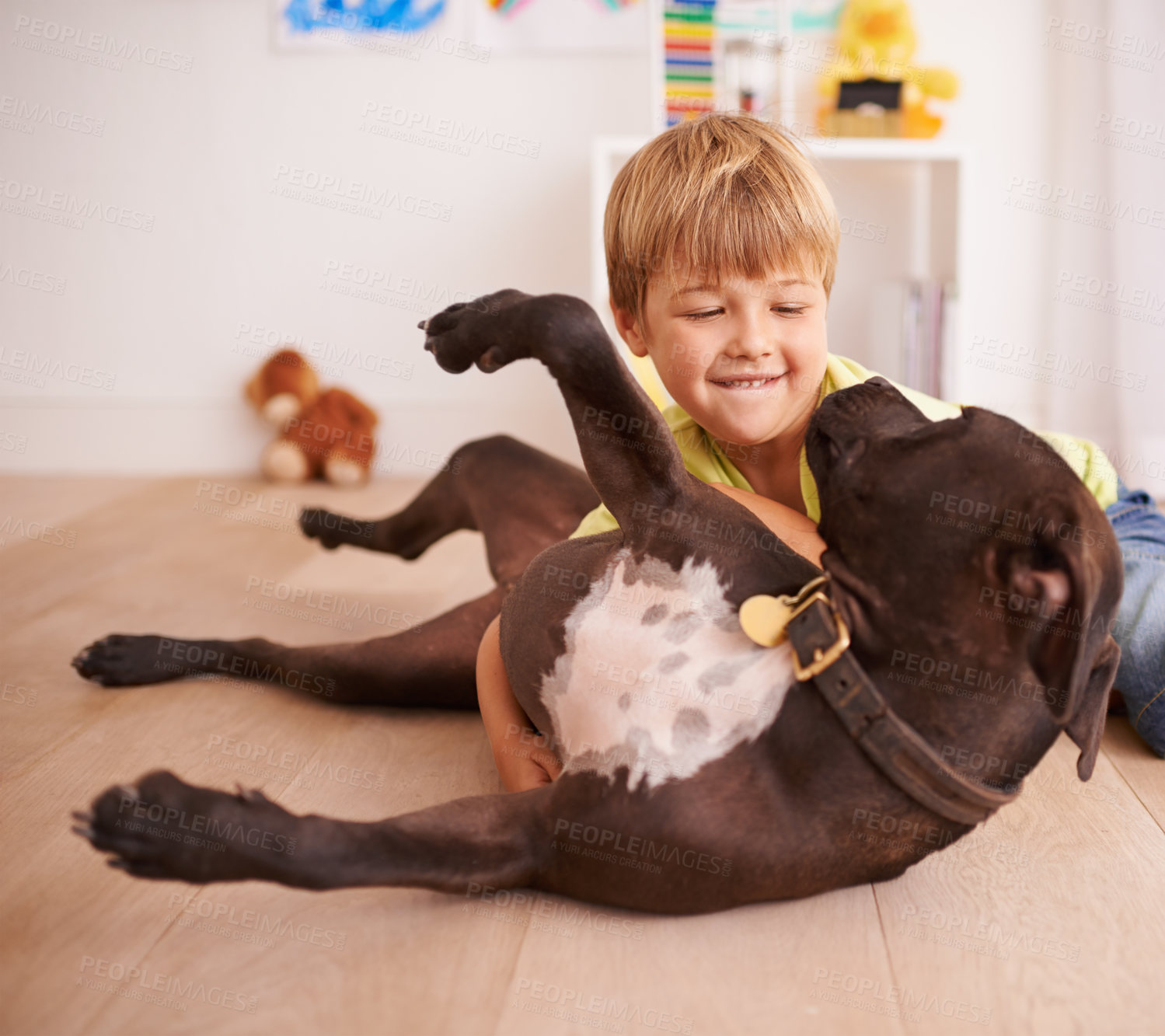 Buy stock photo A little boy playing with his dog in his room
