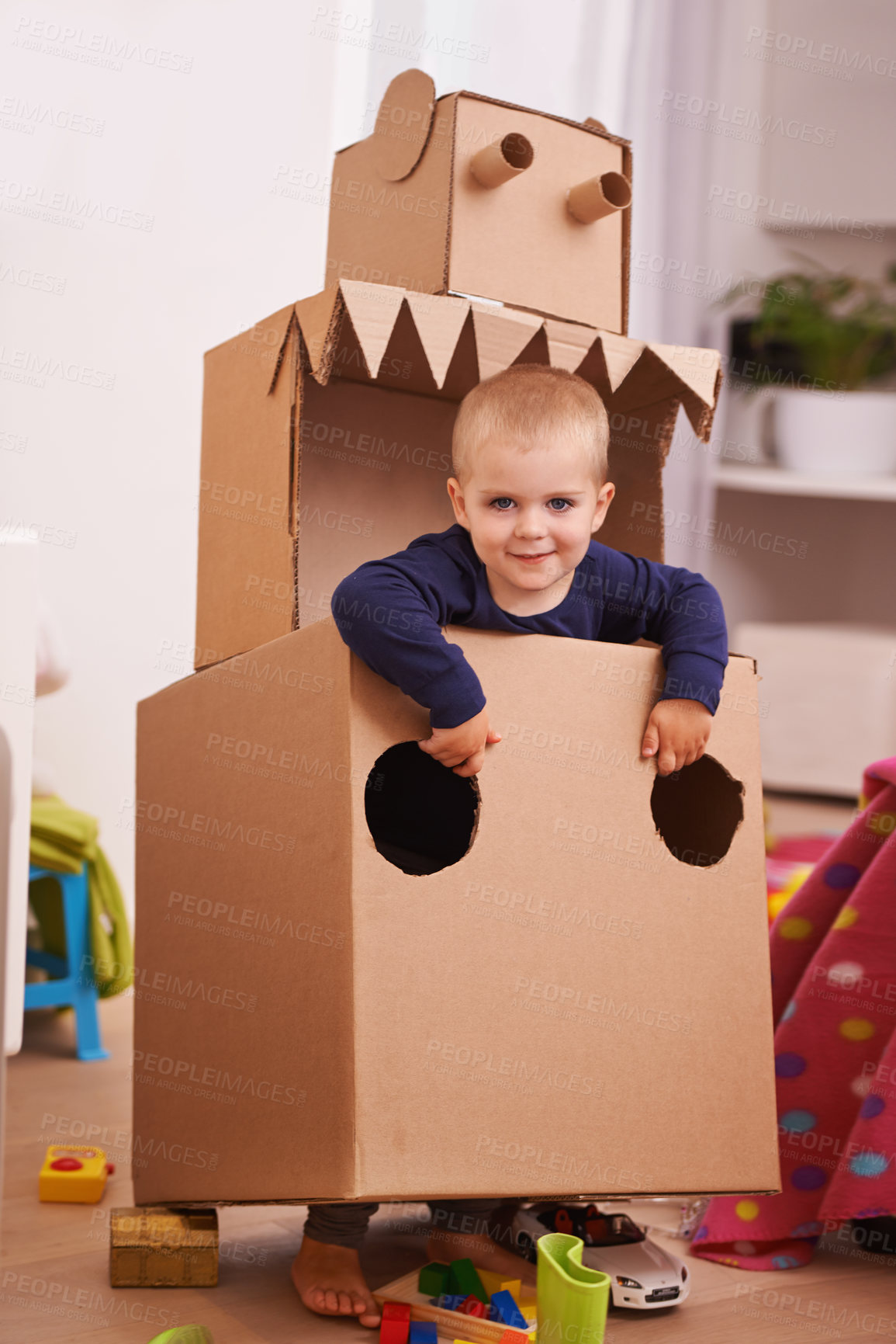 Buy stock photo A young boy playing with a cardboard box cut into the shape of a robot