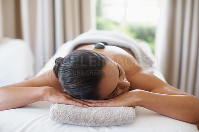 Buy stock photo Relax, hot stone and woman at spa for massage, peace and calm for skincare at luxury resort. Beauty, therapy and person at salon with rocks on back for body treatment, health or rest for wellness