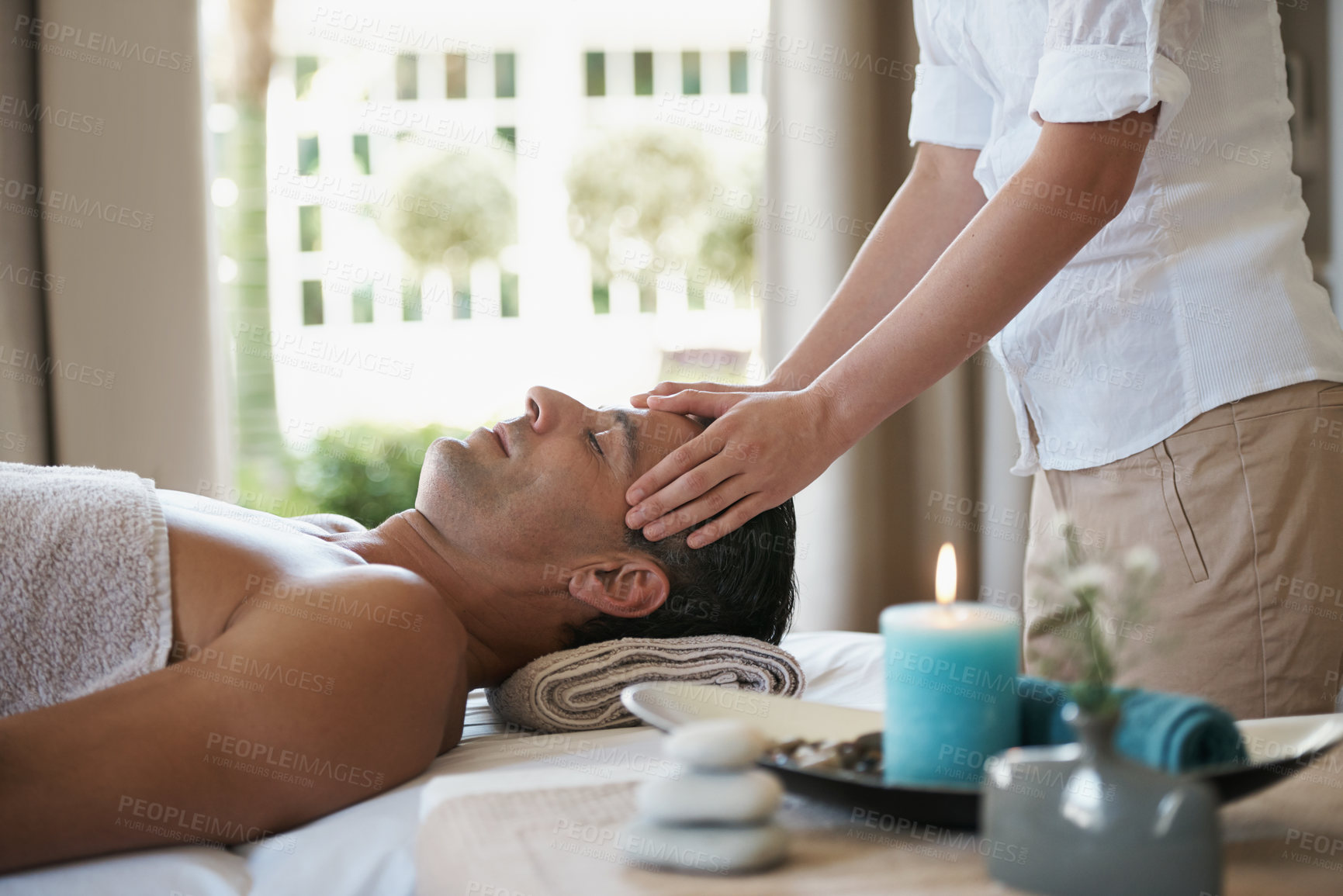Buy stock photo Relax, head massage and man at spa for skincare, peace and calm at luxury resort at table for wellness. Beauty, therapy and person at salon for face treatment, health and hands of masseuse pampering