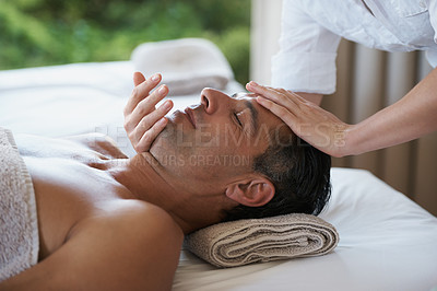 Buy stock photo Relax, face massage and man at salon for skincare, peace and calm at luxury resort at table for wellness. Beauty, therapy and masseuse at spa for head treatment, health and hands of person pampering