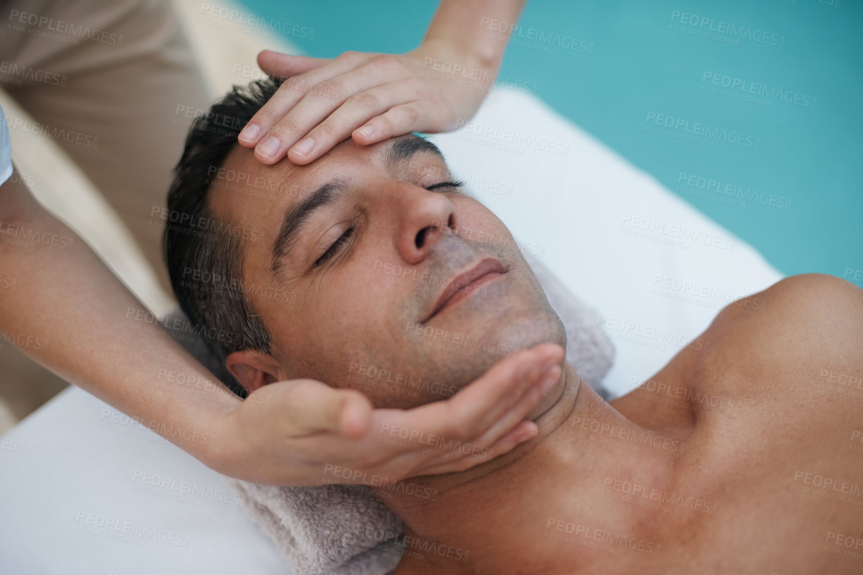 Buy stock photo Hotel, spa and man relax for facial massage on table in resort, calm and care for body in vacation. Holiday, luxury and male person on break for weekend and lodge with treatment for skincare