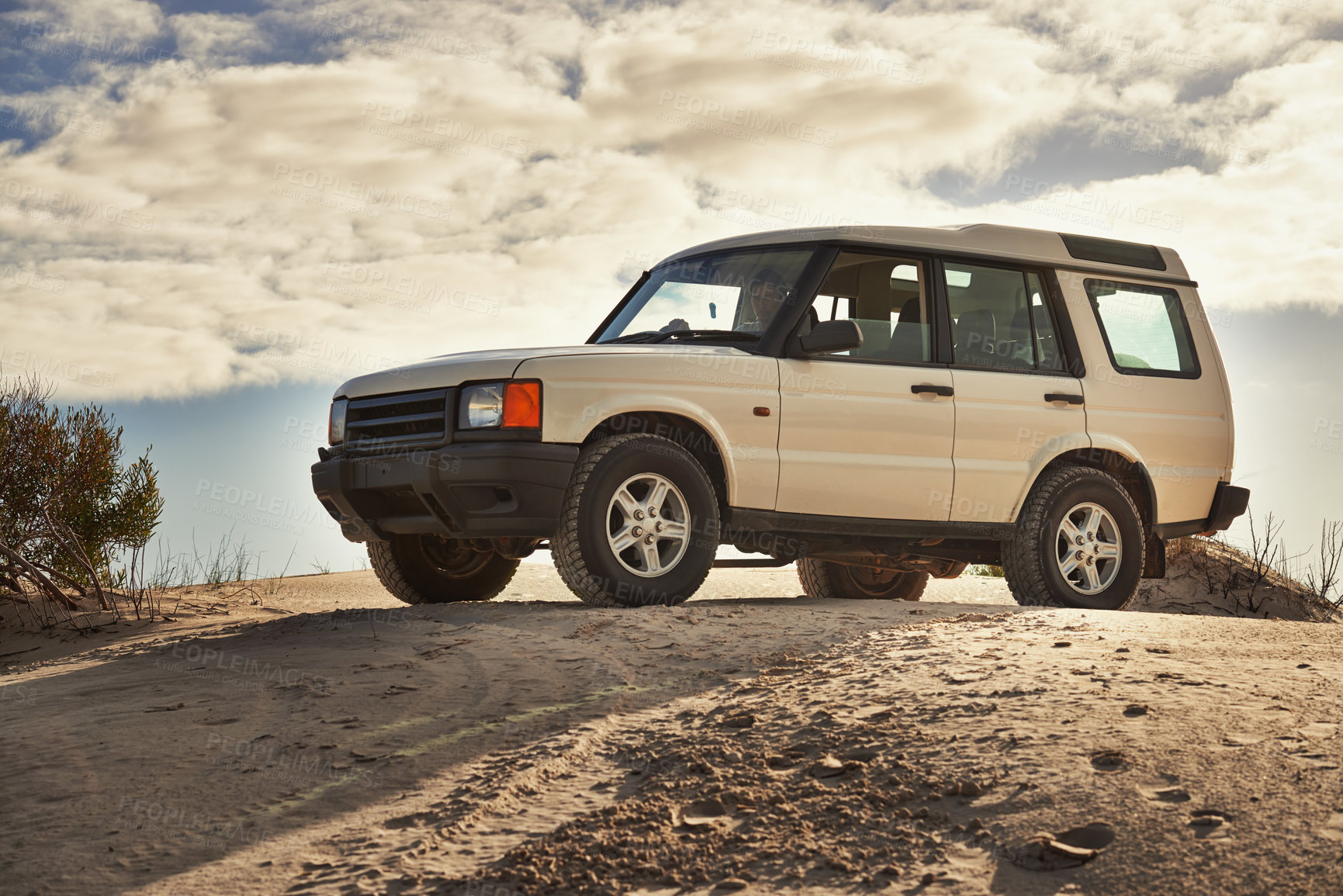 Buy stock photo Shot of a heavy duty 4x4 driving along some sand dunes