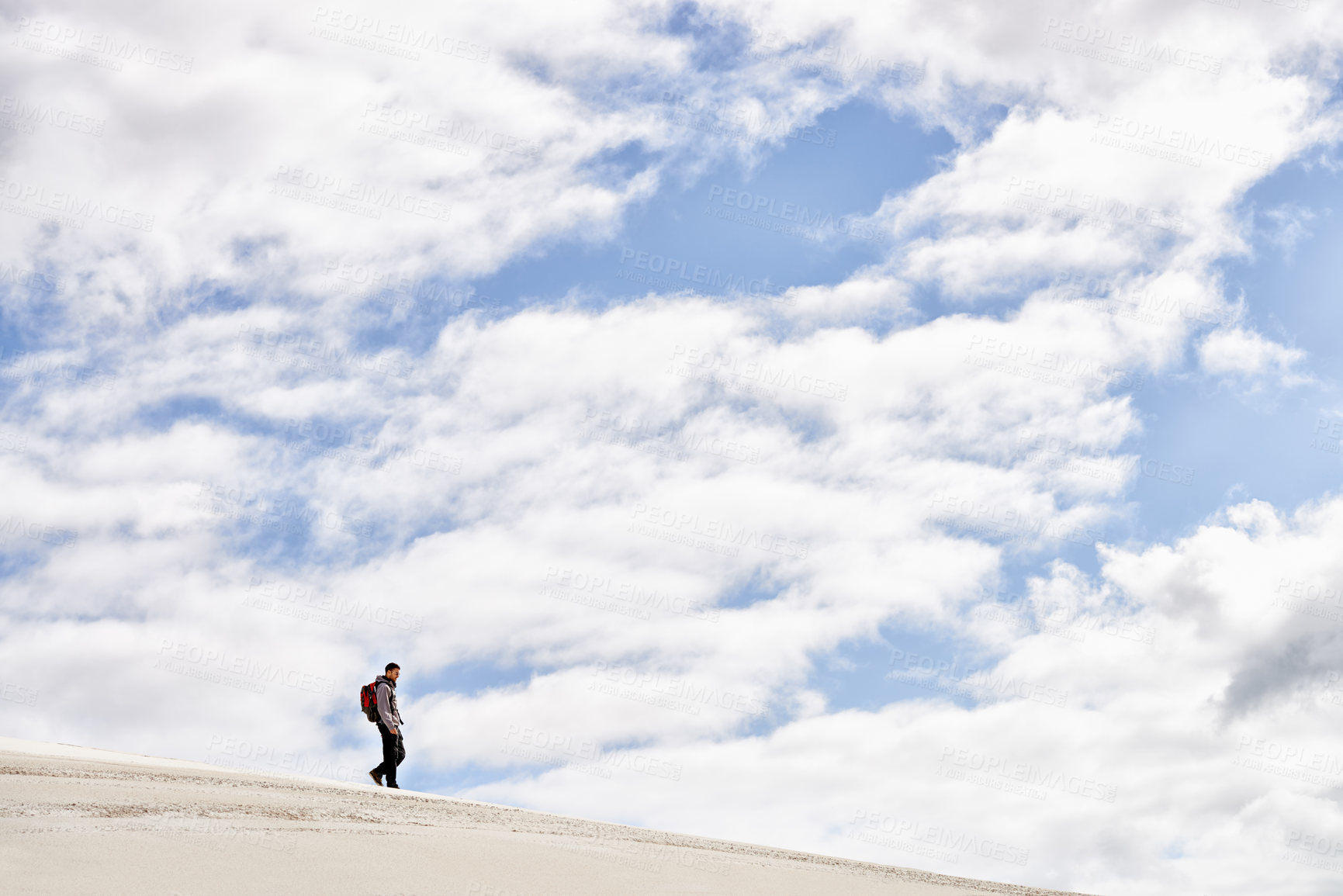 Buy stock photo Hike, dunes and sky with male person in nature for adventure, walk and desert landscape with clouds. Fitness, travel and nomad man people in Sahara, outdoor and hiking in dry climate and scenery