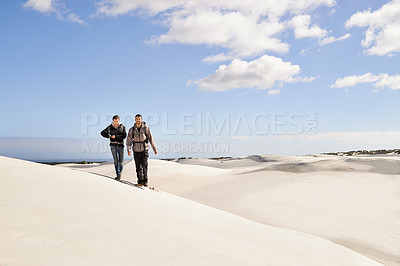 Buy stock photo Couple, hiking and sand outdoor or desert with dune, sky and clouds for walking, climbing and move for recreation. Man, woman and young for adventure in weather and dry for season and destination