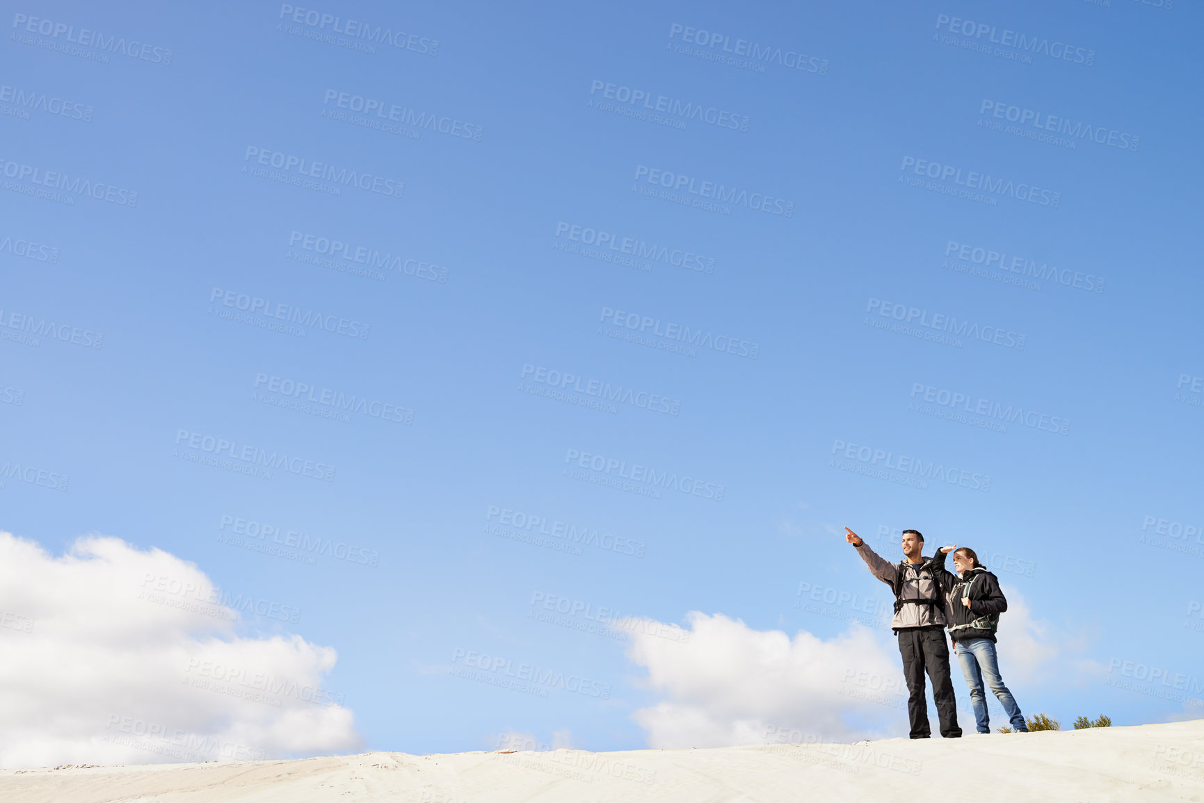 Buy stock photo sand dunes, space and couple hiking for adventure, desert and travel on outdoor holiday for love or view. Sky mockup, explorers trip and nomad people pointing in Sahara terrain, nature or dry climate