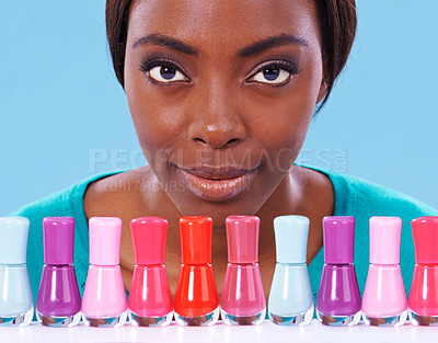 Buy stock photo Woman, nail polish and studio beauty in portrait, cosmetics cosmetology for manicure and pedicure in vibrant row of colours. African female person with options, creative and trendy with product