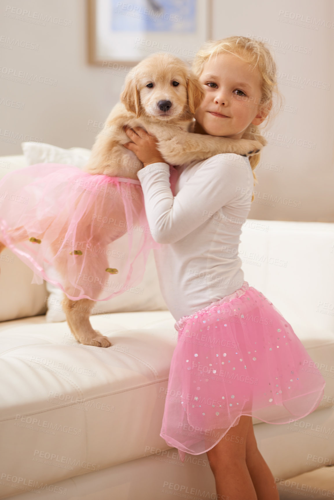 Buy stock photo Child, golden retriever and portrait of a dog and happy girl together for love, care and development. Face of a cute kid and animal puppy in a tutu playing dress up as friends on the home sofa