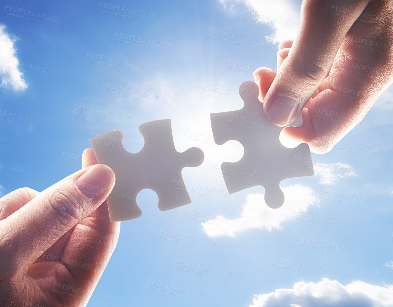 Buy stock photo Hands, puzzle and blue sky with business people team building a solution outdoor from below. Collaboration, teamwork and problem solving with colleagues holding jigsaw pieces for strategy or planning