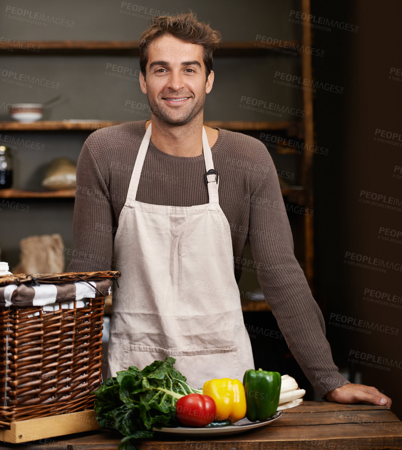 Buy stock photo Portrait of a young man standing in a kitchen with fresh vegetables in front of him