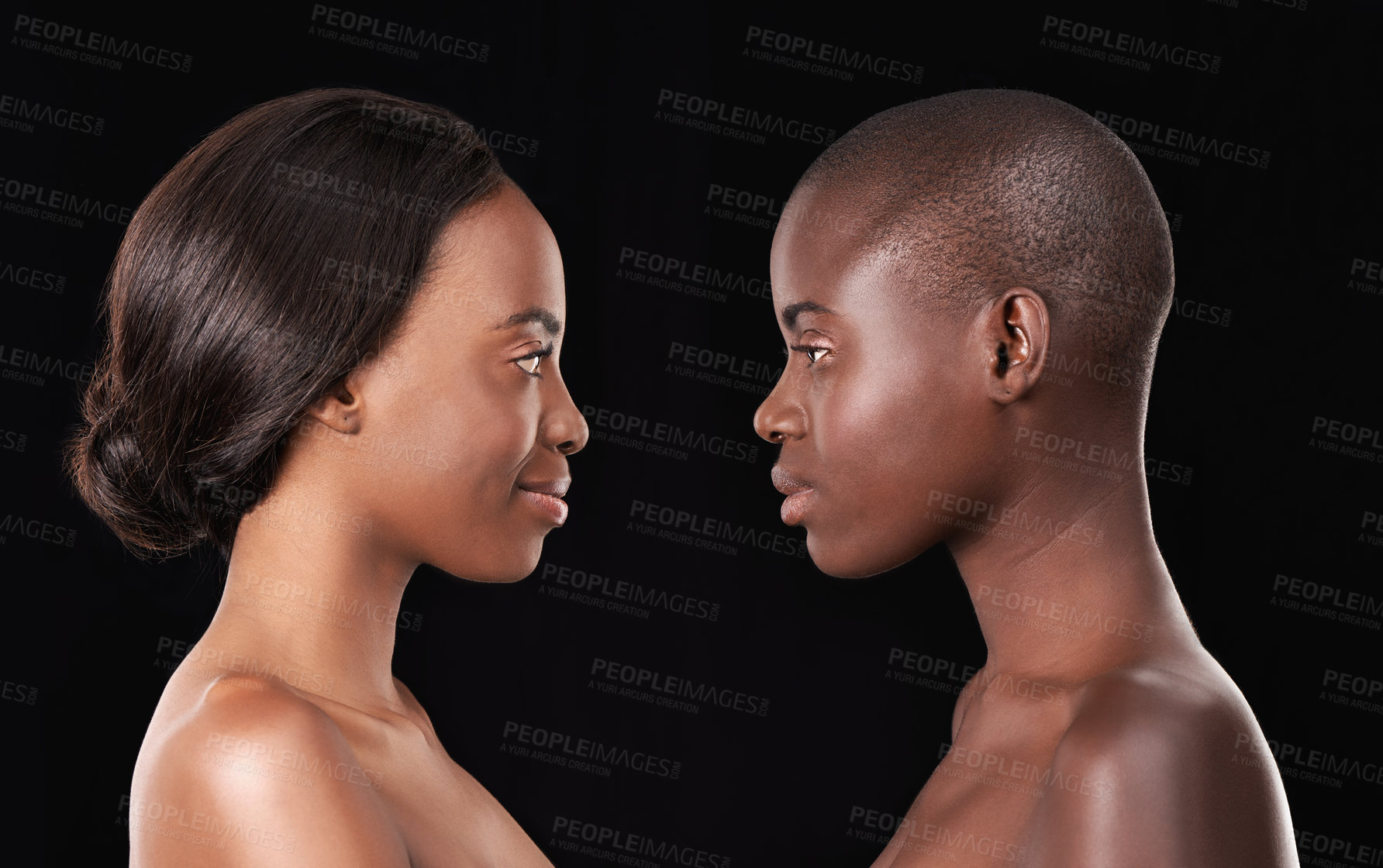 Buy stock photo Two beautiful african women standing face to face against a black background