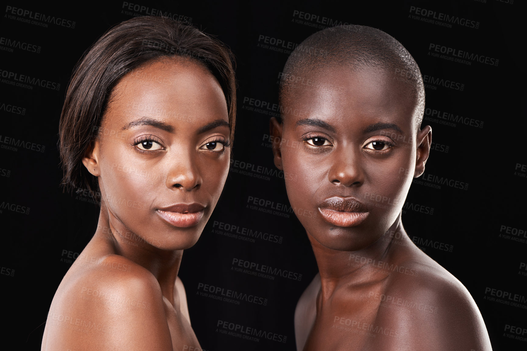 Buy stock photo Portrait of two beautiful african women standing together against a black background