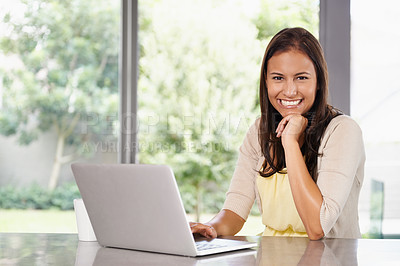 Buy stock photo A young woman working on her laptop at home