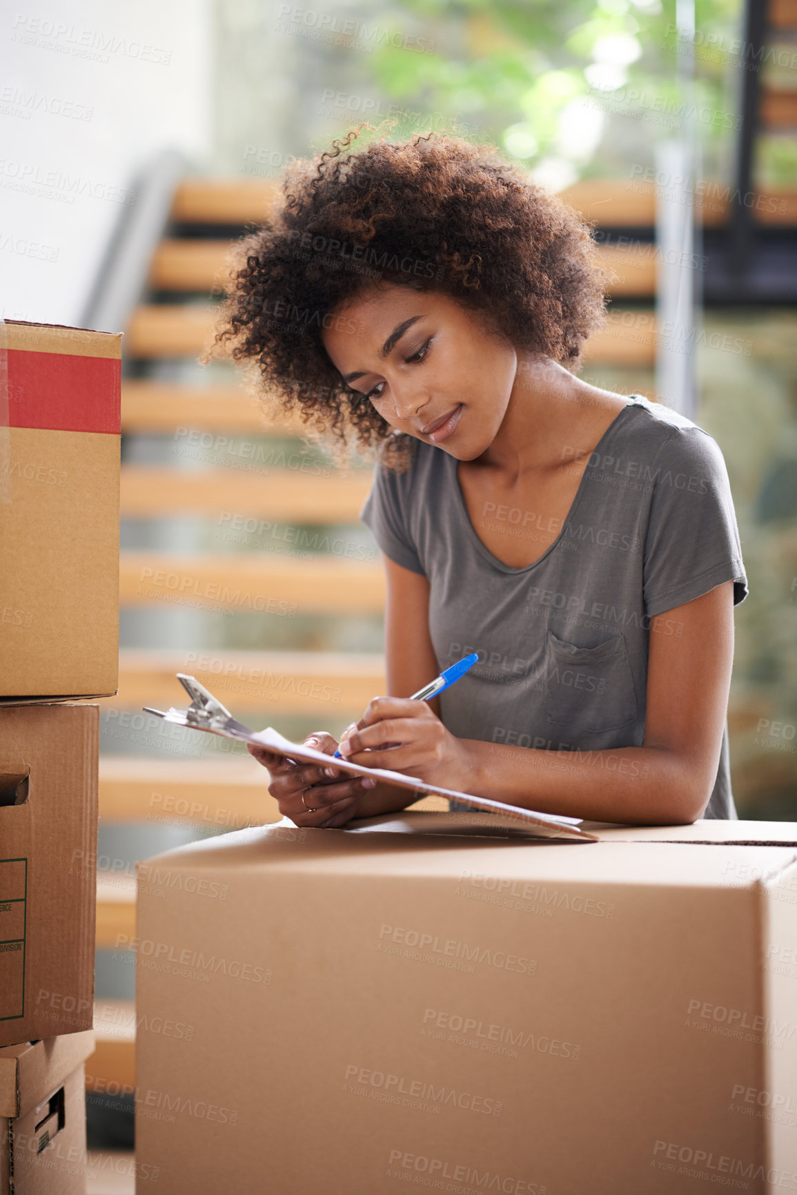 Buy stock photo Shot of a young woman moving into her new house