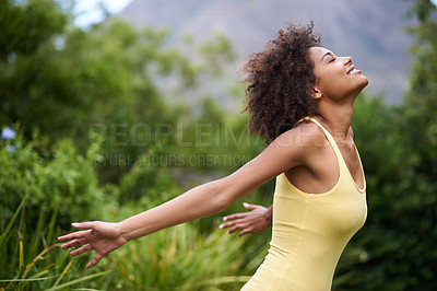 Buy stock photo Shot of a carefree and attractive young woman enjoying time in the outdoors