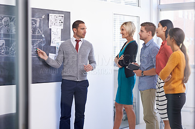 Buy stock photo Creative man, chalkboard and presentation with team for storyboard, development or meeting at office. Male couch talking to group of employees for project planning, production or startup at workplace