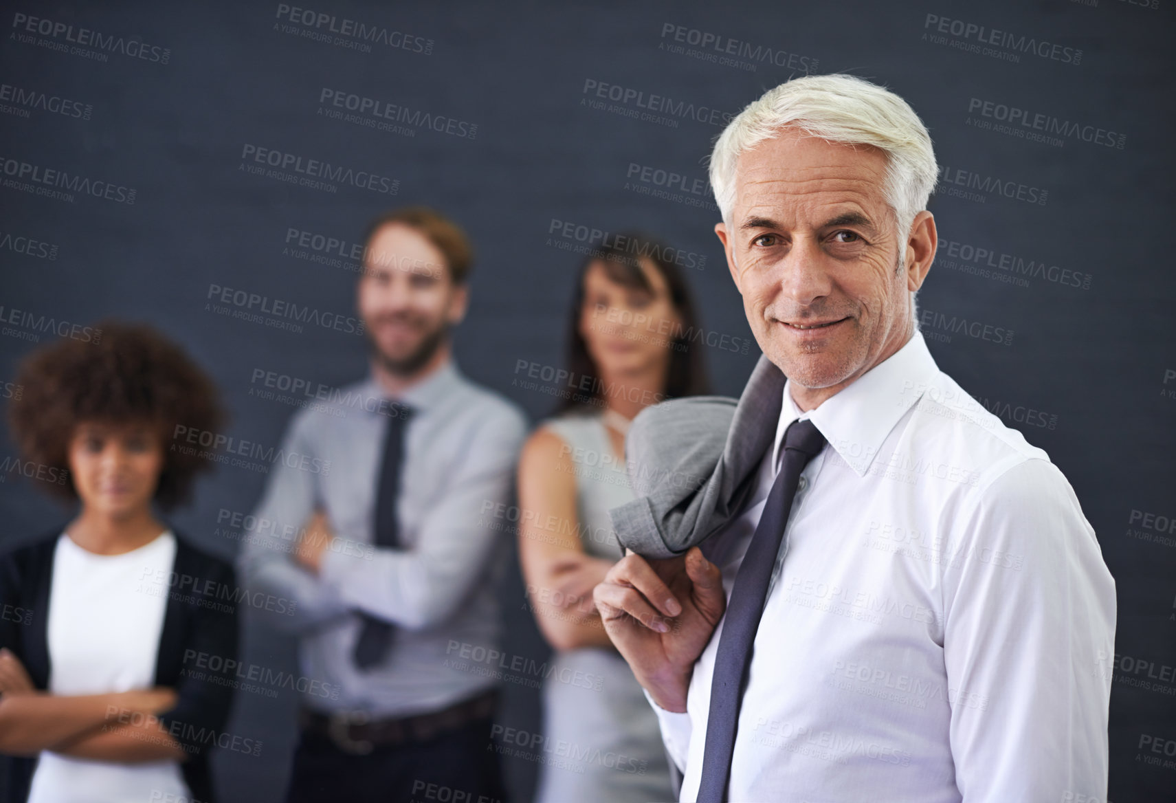 Buy stock photo Shot of a mature professional man standing in front of a group of coworkers