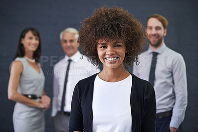 Buy stock photo Shot of a young professional woman standing in front of a group of coworkers