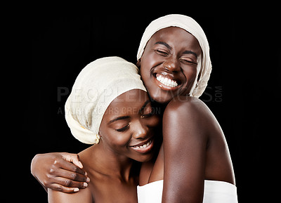 Buy stock photo Black women, head wrap and beauty with hug, skincare and cosmetics in studio with bonding. Girl friends, happy smile and African scarf with wellness and skin glow with makeup and dark background