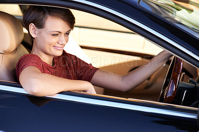 Buy stock photo Shot of a beautiful young woman driving a luxury car