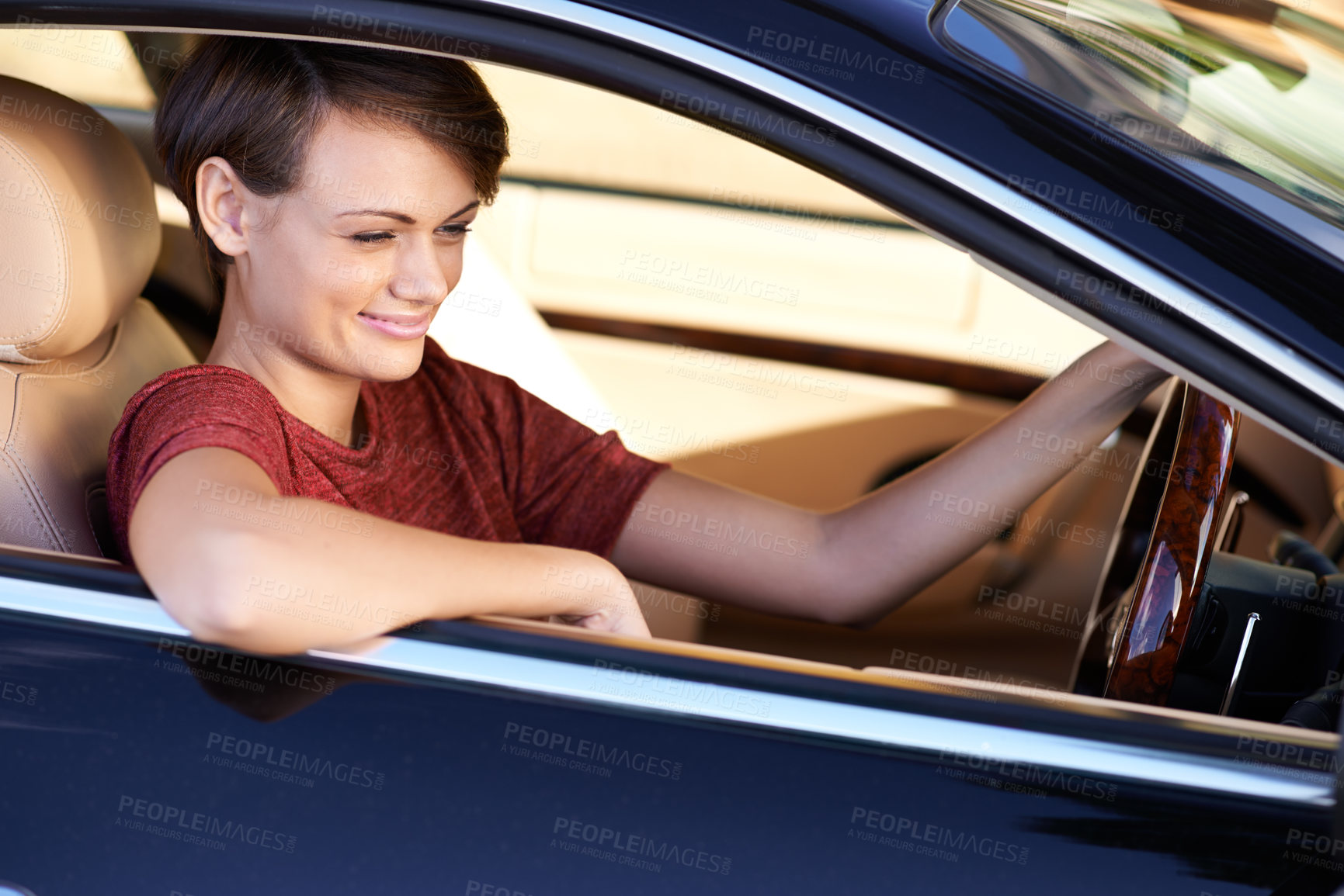 Buy stock photo Shot of a beautiful young woman driving a luxury car