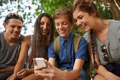 Buy stock photo Friends, smile and phone for social media in nature, together and support outdoors. People, forest and group of happy teens for bonding, internet and app or website for funny meme or conversation
