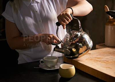 Buy stock photo Cropped shot of a young woman making a cup of tea in her kitchen