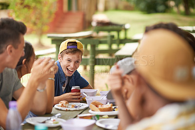 Buy stock photo Teenager, happy friends and eating lunch outdoor at party for celebration together at park in summer. Group, students and food at table in garden, drinking and people laughing at funny conversation