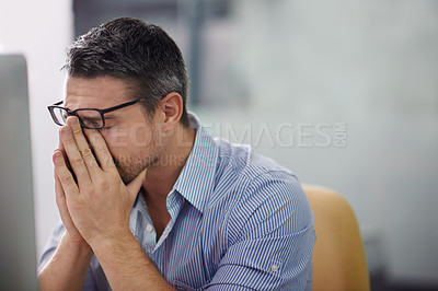 Buy stock photo Cropped shot of a stressed businessman sitting at his desk