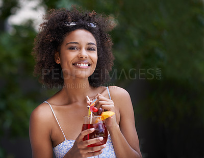 Buy stock photo Shot of an attractive young woman enjoying a cocktail outside