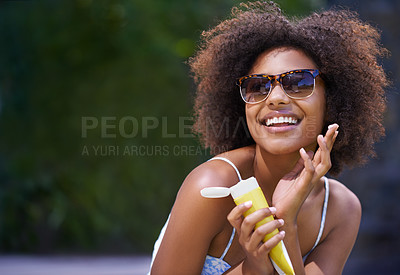 Buy stock photo Shot of an attractive female holding sunscreen