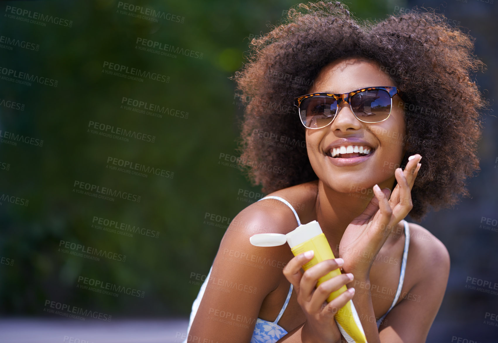 Buy stock photo Shot of an attractive female holding sunscreen
