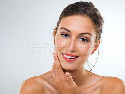Buy stock photo Cropped studio portrait of a beautiful young woman touching her face