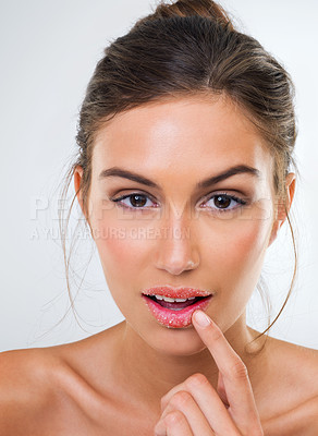 Buy stock photo Cropped studio portrait of a beautiful young woman touching her lip