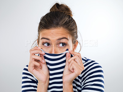 Buy stock photo Shot of a beautiful young woman using her shirt to cover her mouth and nose
