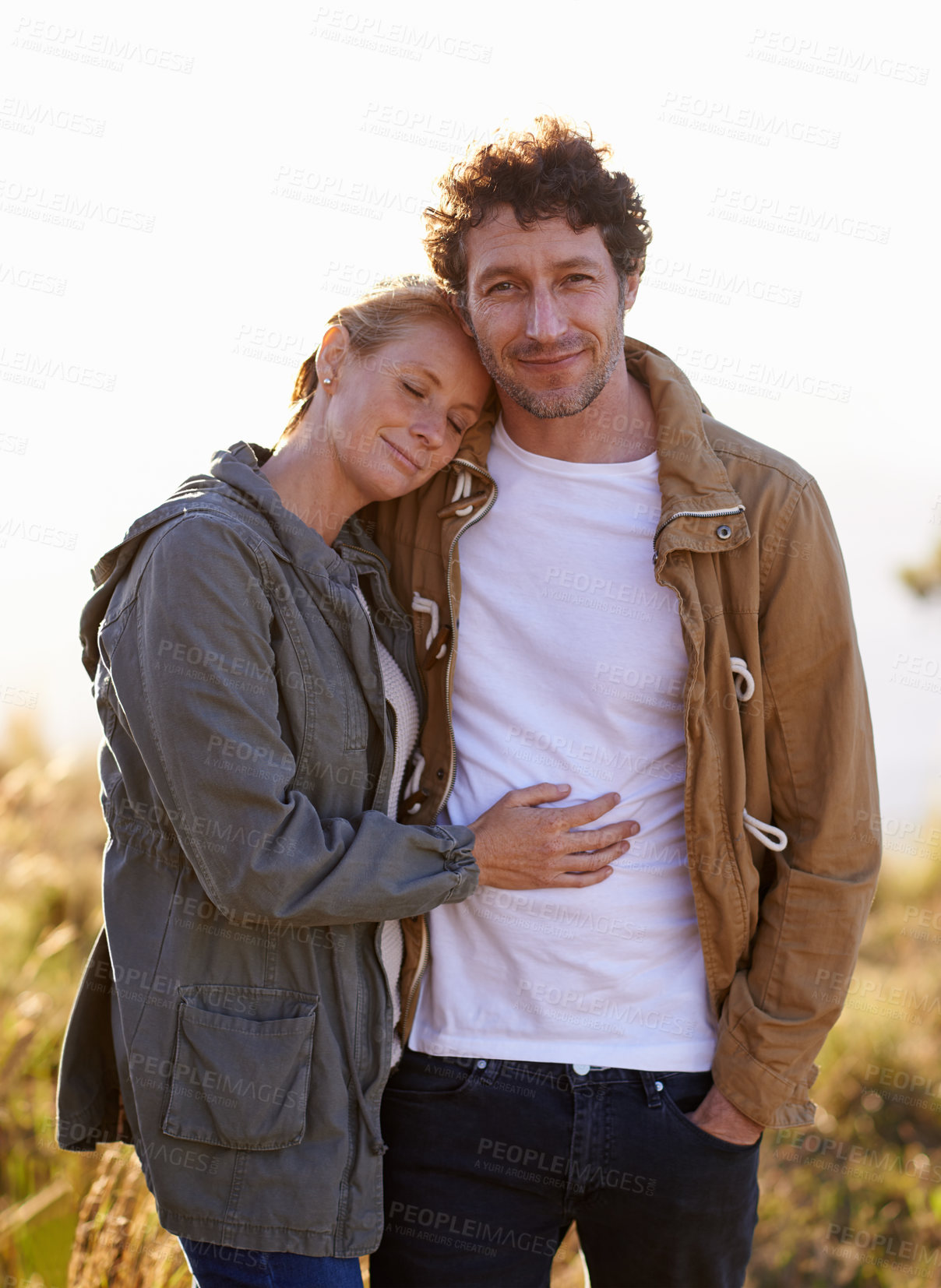 Buy stock photo Couple, hug in nature and portrait in park, love and support with date for bonding and time together. Sunset, calm and people in forest for fresh air, loyalty and commitment with peace outdoor