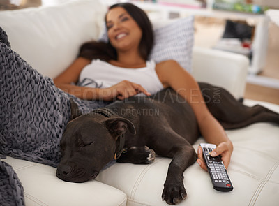 Buy stock photo Shot of an attractive young woman relaxing on the sofa with her dog