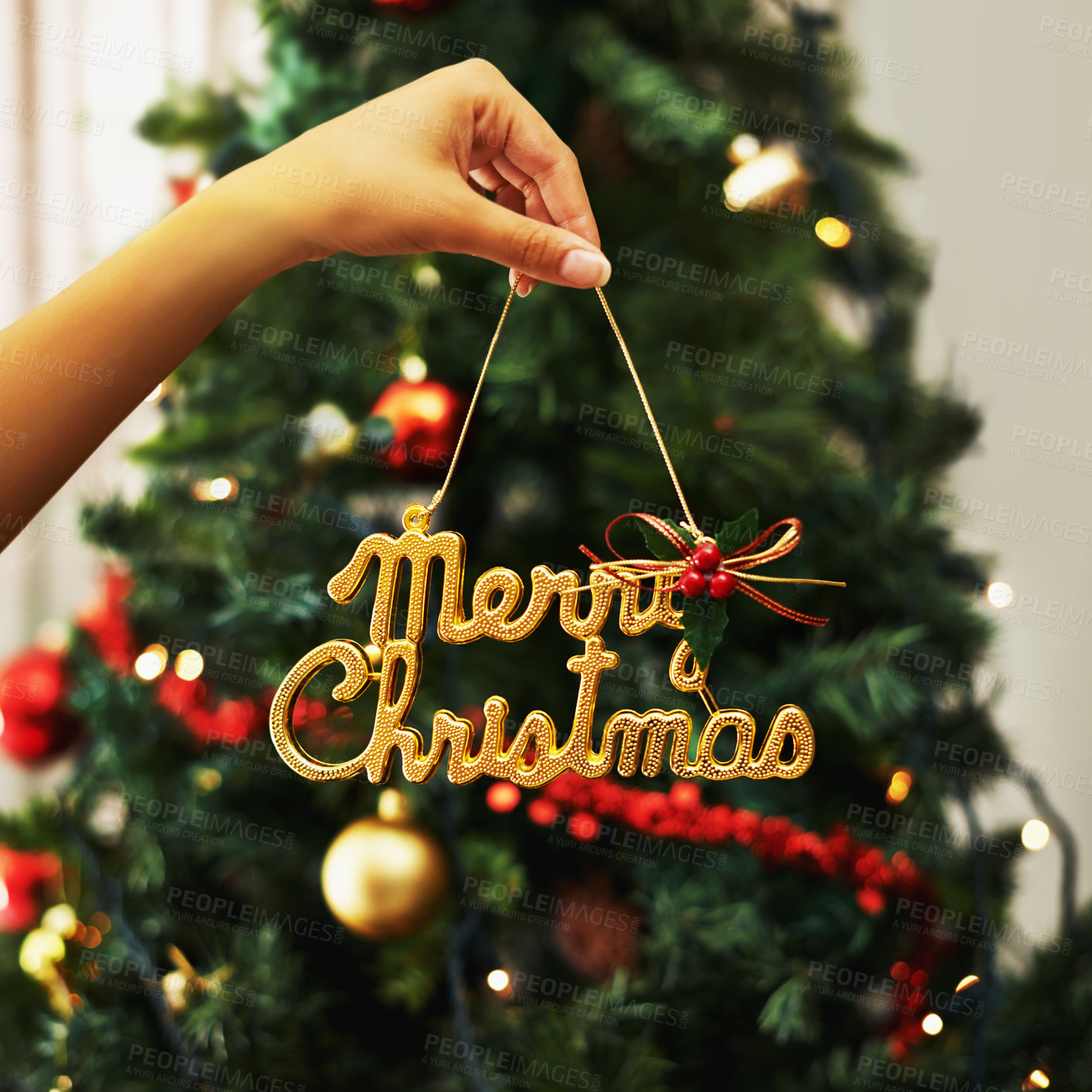 Buy stock photo Woman hand and festive decoration, Christmas sign with tree in the background in home living room. Female Hands with icon, festive holiday, celebration and xmas decorations, creative and 
 gold