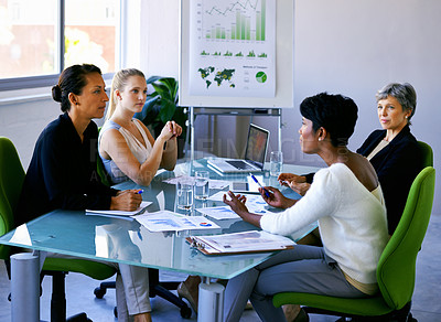 Buy stock photo Shot of four businesswomen during a business meeting